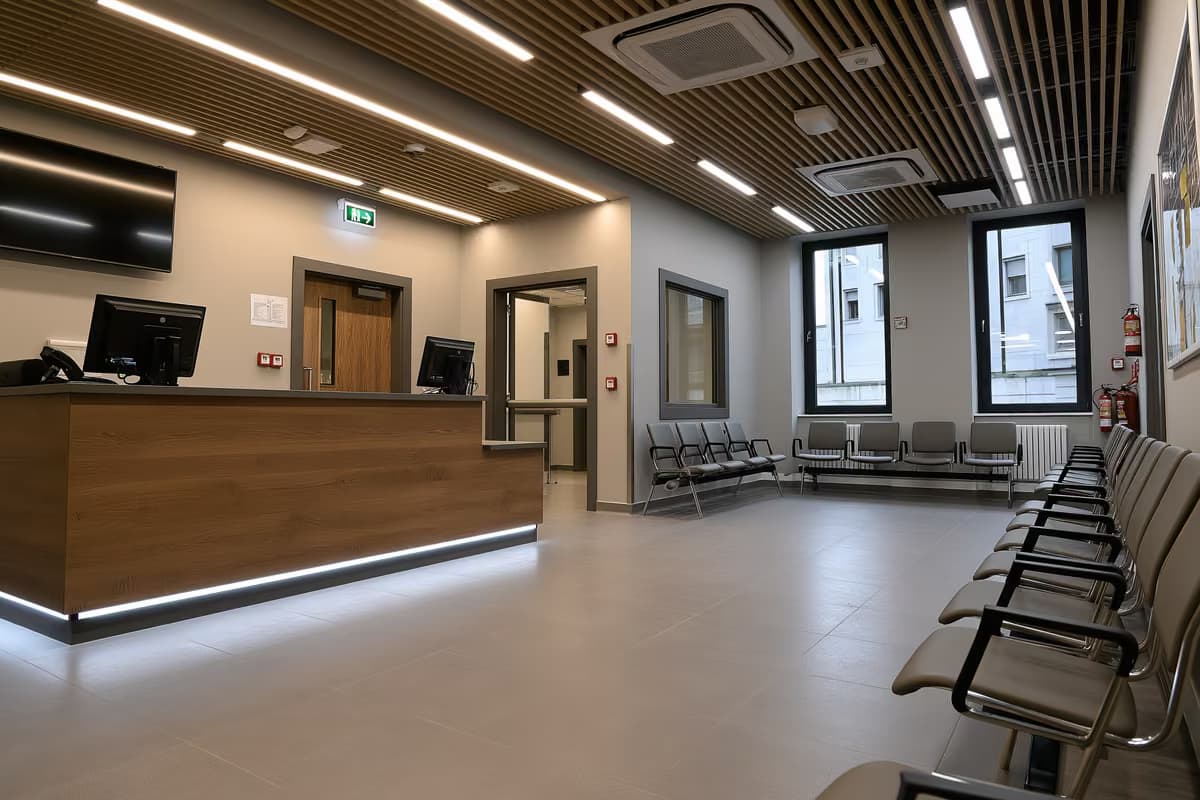 Egy hivatalos kiszolgálópult és üres várakozószékek egy csendes nyilvános irodában.