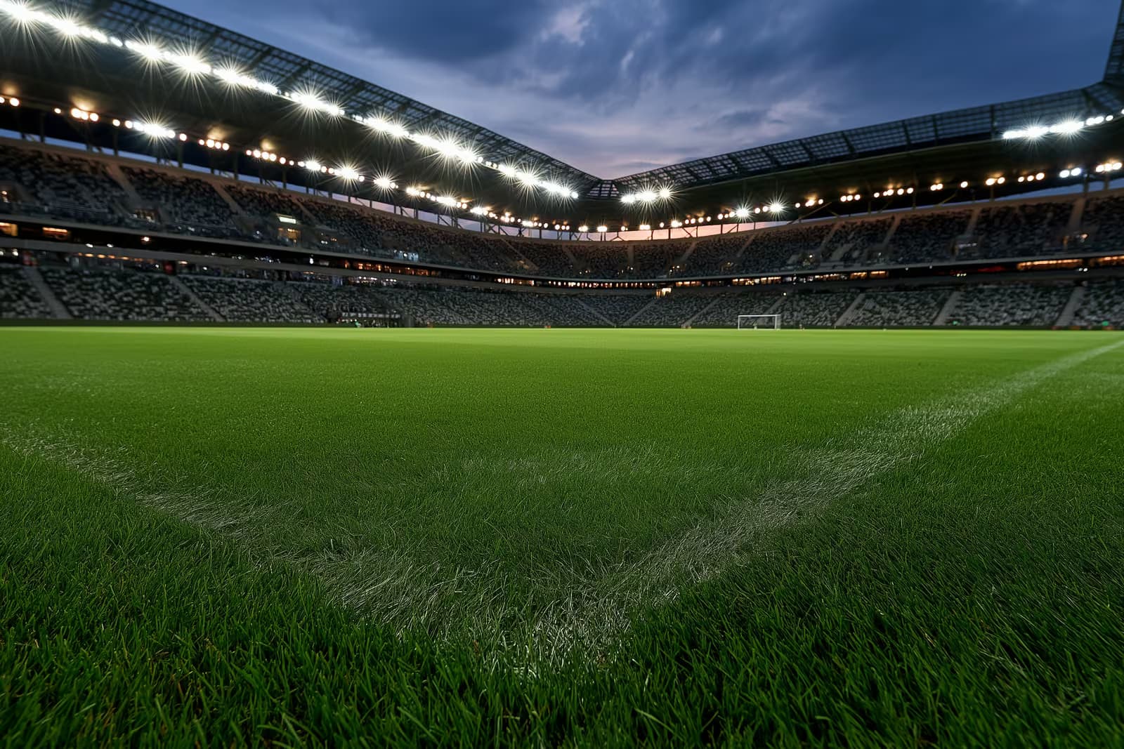 Egy kivilágított futballstadion alkonyatkor egy esti mérkőzés előtt.
