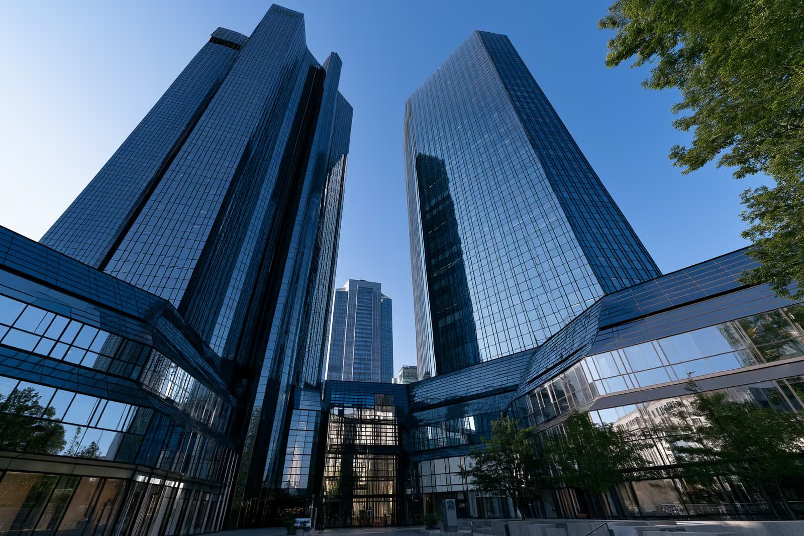 Frankfurt iker üveg banktornyai csillognak a ragyogó kék ég alatt, alulról nézve.
